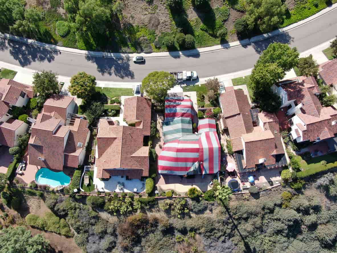 Aerial view of a neighborhood, including a house that has been tented for termites.