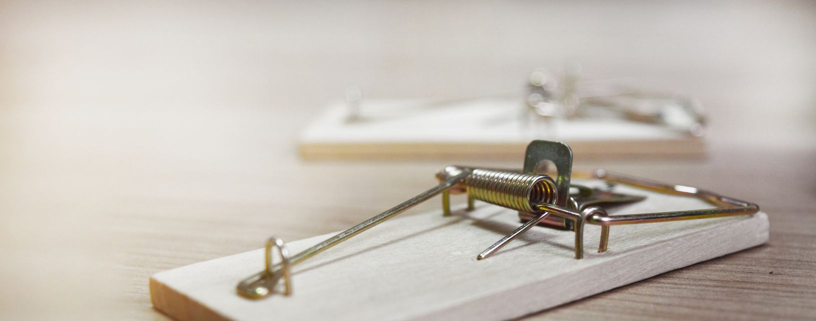 Mousetraps without bait on a wooden table.